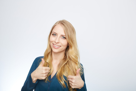 Young Woman Showing Thumb Up Sign On White Backgroundの写真素材
