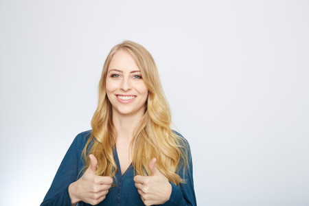 Young Woman Showing Thumb Up Sign On White Backgroundの写真素材