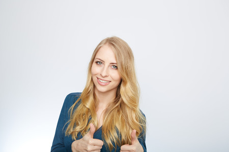 Young Woman Showing Thumb Up Sign On White Backgroundの写真素材