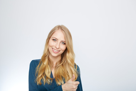 Young Woman Showing Thumb Up Sign On White Backgroundの写真素材