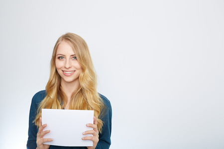 Happy smiling young business woman showing blank signboard, isolated over white backgroundの写真素材