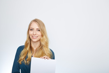 Happy smiling young business woman showing blank signboard, isolated over white backgroundの写真素材