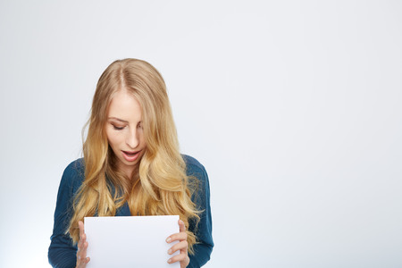 Happy smiling young business woman showing blank signboard, isolated over white backgroundの写真素材