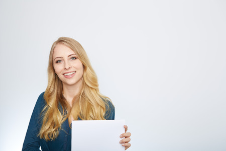 Happy smiling young business woman showing blank signboard, isolated over white backgroundの写真素材