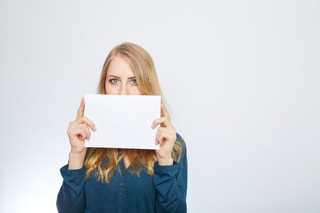 Happy smiling young business woman showing blank signboard, isolated over white backgroundの写真素材