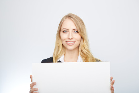 a pretty blonde girl with a blank presentation boardの写真素材