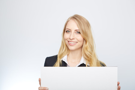 a pretty blonde girl with a blank presentation boardの写真素材