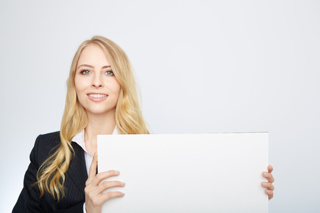 a pretty blonde girl with a blank presentation boardの写真素材