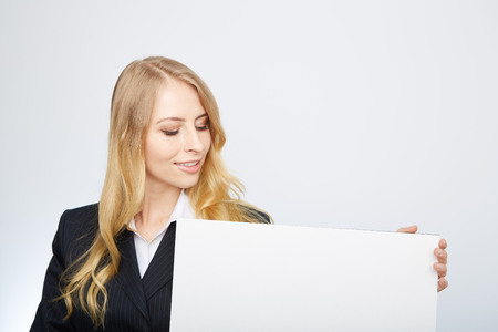 a pretty blonde girl with a blank presentation boardの写真素材