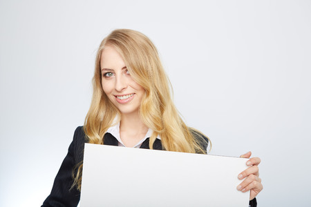 a pretty blonde girl with a blank presentation boardの写真素材