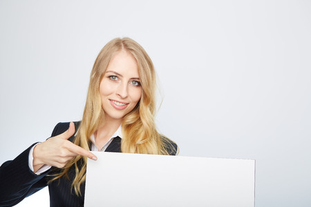 a pretty blonde girl with a blank presentation boardの写真素材