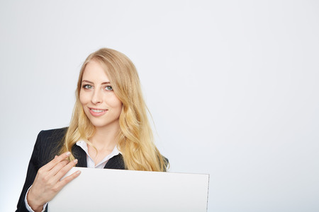 a pretty blonde girl with a blank presentation boardの写真素材