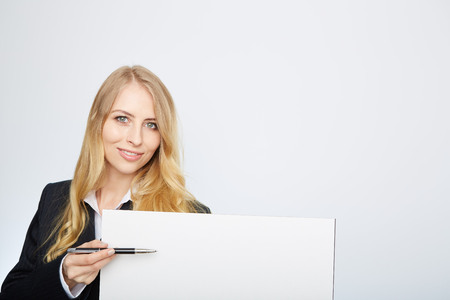 a pretty blonde girl with a blank presentation boardの写真素材