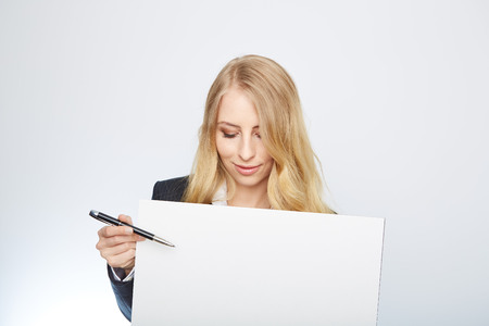 a pretty blonde girl with a blank presentation boardの写真素材