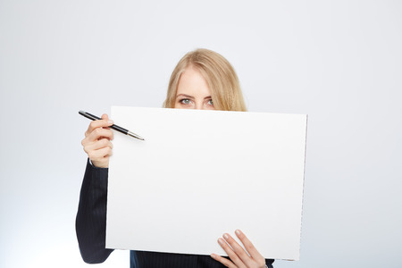 a pretty blonde girl with a blank presentation boardの写真素材