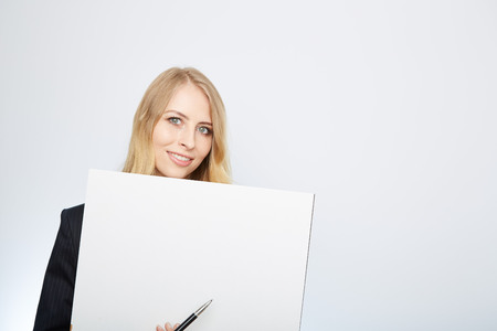 a pretty blonde girl with a blank presentation boardの写真素材