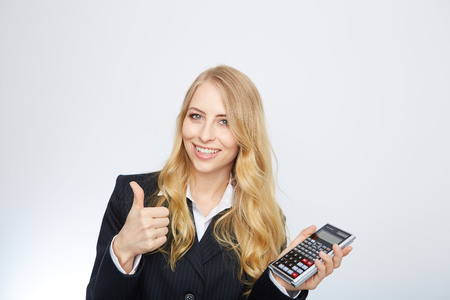 attractive smiling business woman with calculator isolated on whiteの写真素材