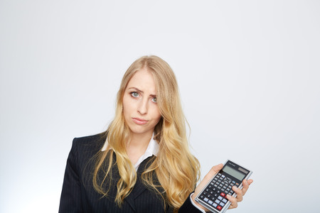 attractive smiling business woman with calculator isolated on whiteの写真素材