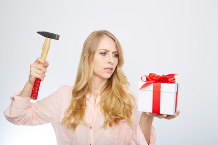 Beauty with gift box an a hammer in her hand.の写真素材