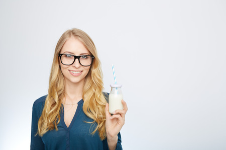 a young woman with a glass of milk. isolated on white.の写真素材