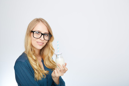 a young woman with a glass of milk. isolated on white.の写真素材