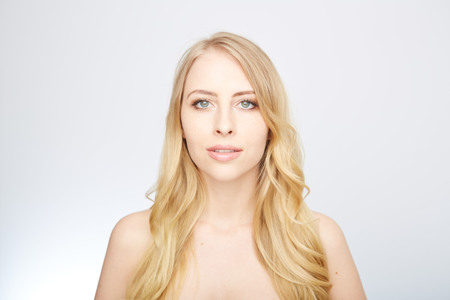 Beautiful woman with long straight blond hair. Fashion model posing at studio.の写真素材