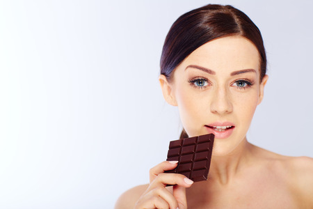 woman with a chocolate in hand. isolatedの写真素材