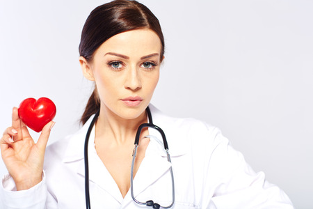 female doctor holding a heart, isolated on white backgroundの写真素材