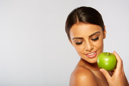 Smiling woman with apple isolated on whiteの写真素材
