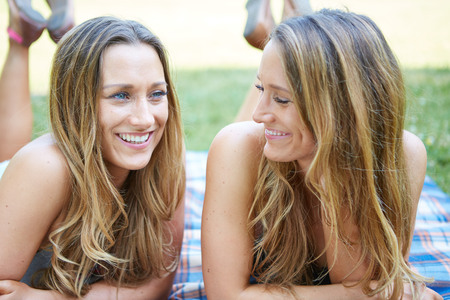 Two Female Friends Enjoying Picnic Together in Natureの写真素材