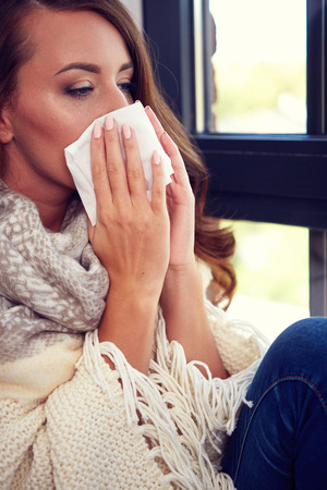 Flu. Closeup image of frustrated sick woman with red noseの写真素材
