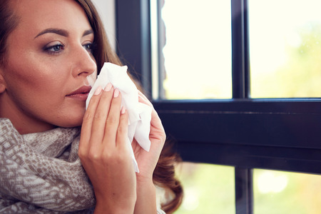 Flu. Closeup image of frustrated sick woman with red noseの写真素材