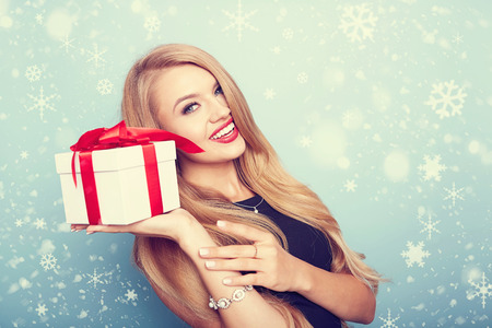 christmas, x-mas, valentine's day, celebration concept. smiling woman in red dress with gift boxの写真素材