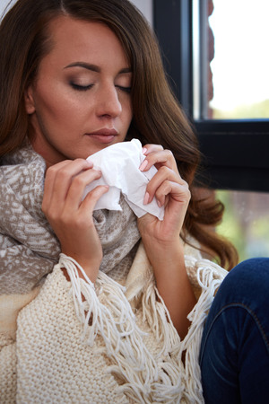 Flu. Closeup image of frustrated sick woman with red noseの写真素材