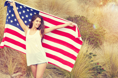 woman holding USA flag outdoor, independence day, 4th of julyの写真素材