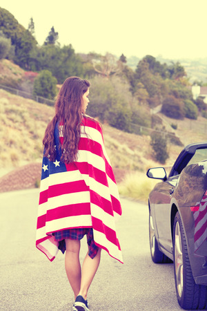 Woman wearing American Flag, walking on the streetの写真素材