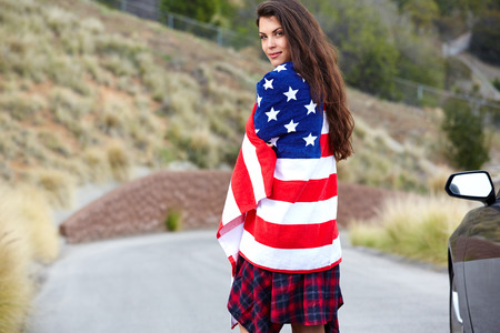 Woman wearing American Flag, walking on the streetの写真素材