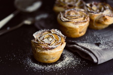 mini apple roses puff pastry on a dark background.の写真素材