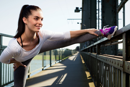 young woman streching before sports. urban style