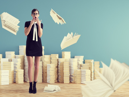 young woman standing infront of stack books. education concept.の写真素材
