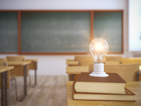 light bulb on books in empty school classroom. 3d renderingの写真素材