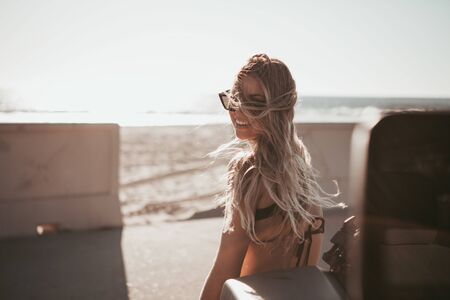 surfer girl standing by a car at the beach. california lifestyleの写真素材