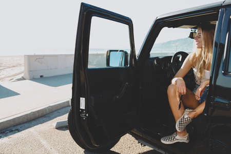 surfer girl sitting at a car in Malibu. On film Californiaの写真素材