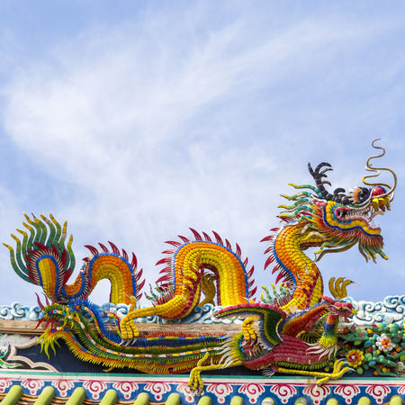 Chinese dragon on blue sky with cloud top of templeの写真素材