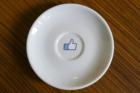 CHIANG MAI, THAILAND - SEPTEMBER 24, 2014:  Like us on Facebook icon on white dish, Facebook is a popular free social networking website in the worldのeditorial素材