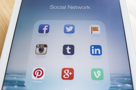 CHIANG MAI, THAILAND - SEPTEMBER 07, 2014: All of popular social media icons on Apple new iPad Air device screen wood background.のeditorial素材
