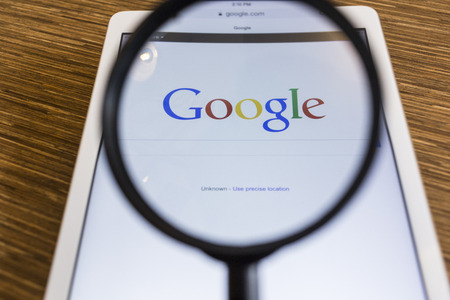 CHIANG MAI, THAILAND - SEPTEMBER 17, 2014: Magnifying glass of Google search page view on web browser Apple iPad Air device.のeditorial素材