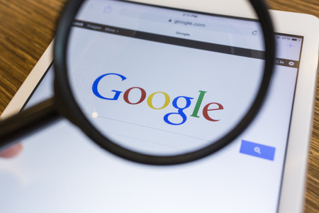 CHIANG MAI, THAILAND - SEPTEMBER 17, 2014: Magnifying glass of Google search page view on web browser Apple iPad Air device.のeditorial素材