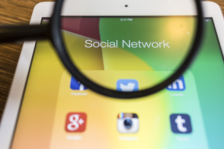 CHIANG MAI, THAILAND - SEPTEMBER 17, 2014: All of popular social media icons on tablet device screen with magnify glass.のeditorial素材