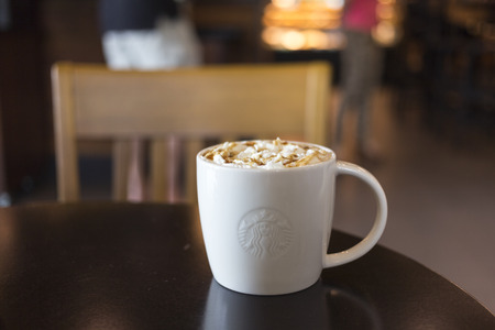 CHIANG MAI, THAILAND - OCTOBER 02, 2014: Starbucks coffee caramel latte white mug in Starbucks Cafe Chiang Mai Thailand. Starbucks is the largest coffeehouse company in the world.のeditorial素材